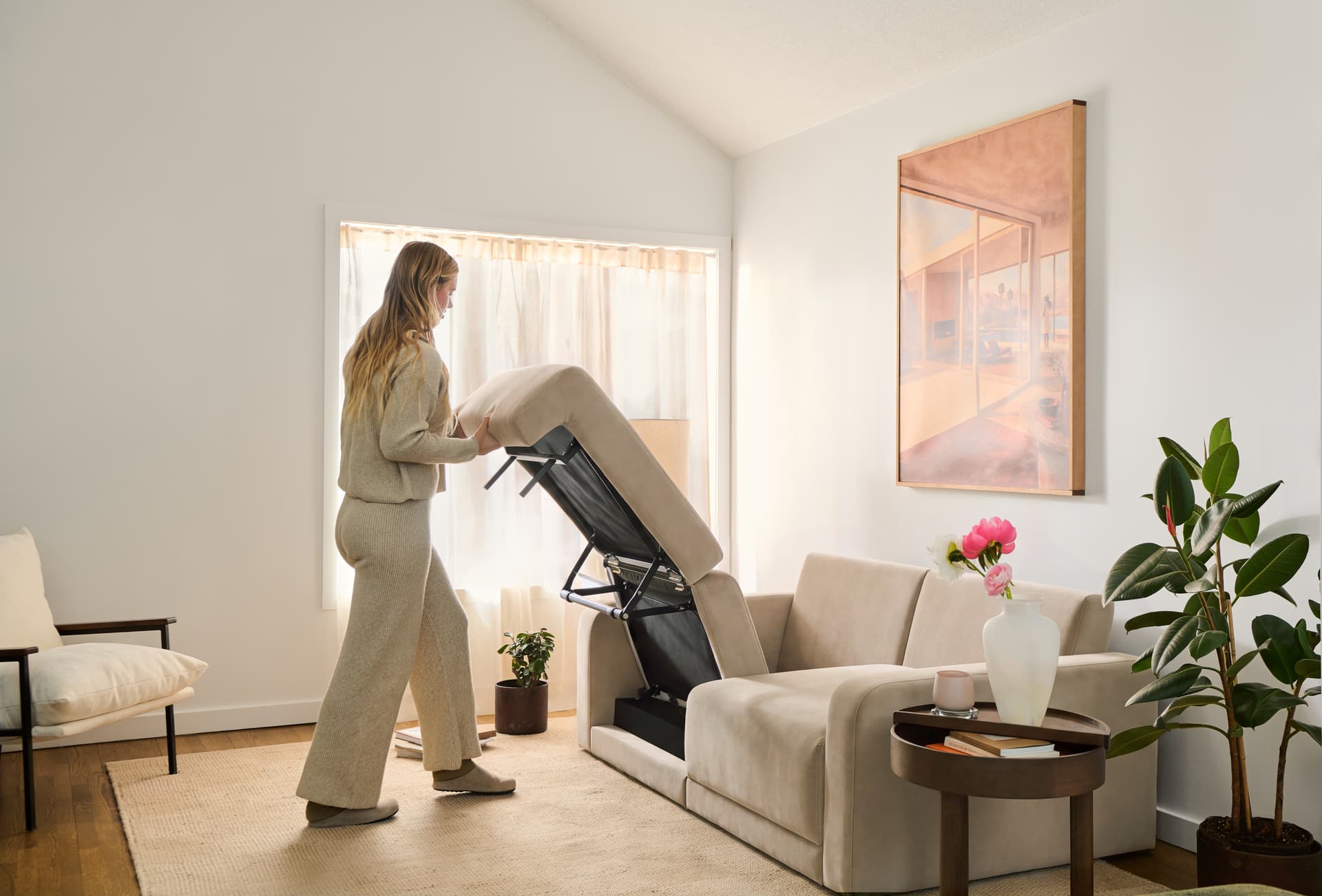 Woman folding up the seat of a Cozey Orian sofa bed in a bright living room