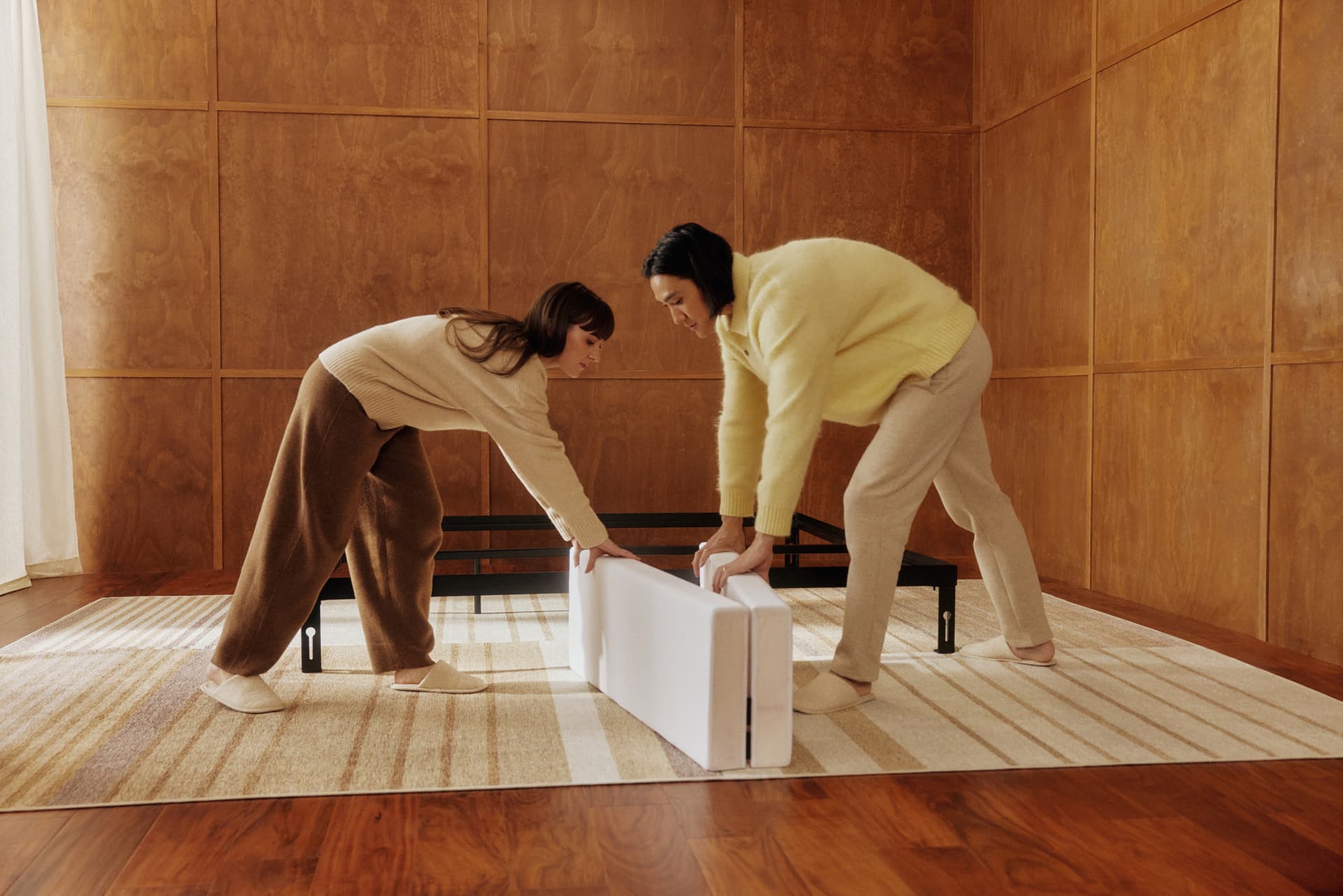 Two people assembling a Cozey Ara bed